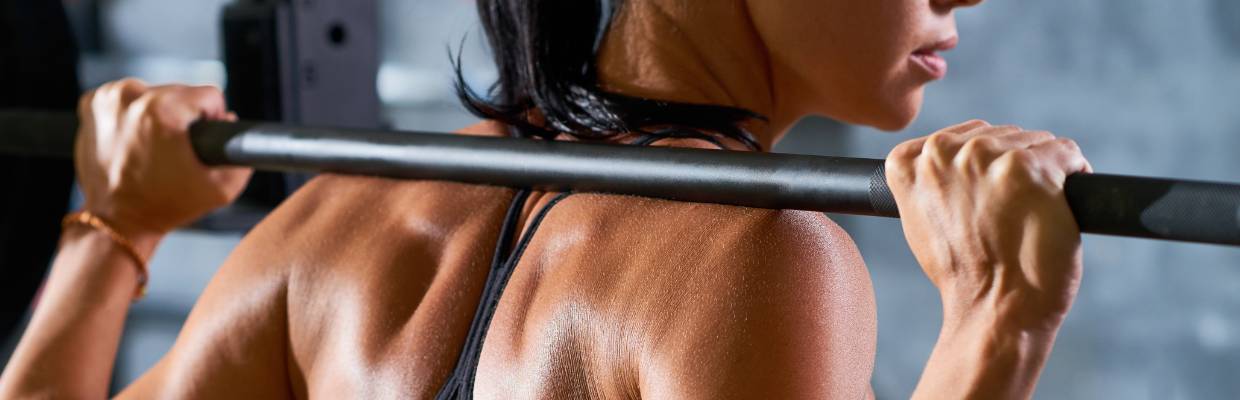 A woman with a barbell on her back