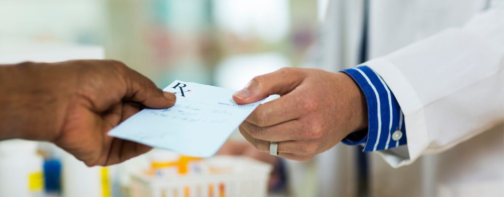 A doctor handing a patient a prescription